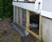These photos show the installation process of the underground fence system with new framing for hardware clothe screening, PVC lattice and composite trim-boards.