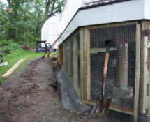 These photos show the installation process of the underground fence system with new framing for hardware clothe screening, PVC lattice and composite trim-boards.